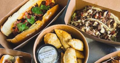 A sandwiches, two tacos, and several pirogies in takeout containers from B'Spoke Kitchen + Market.
