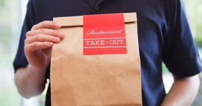 Restaurant employee holding a takeout bag