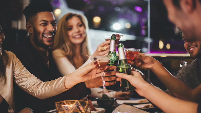 Group of friends drinking at a table at a restaurant together.