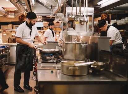 Image of a restaurant kitchen with chefs cooking